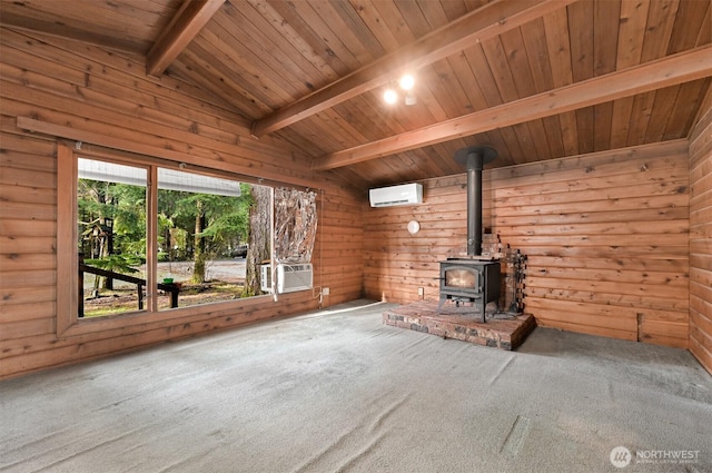 unfurnished living room with wooden walls, carpet floors, a wood stove, vaulted ceiling with beams, and an AC wall unit