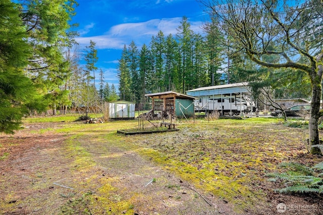 view of yard with a storage shed, an outbuilding, and a detached carport