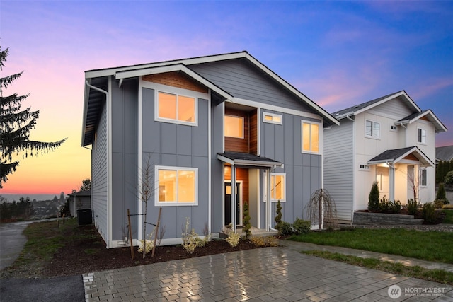 view of front facade with central air condition unit and board and batten siding