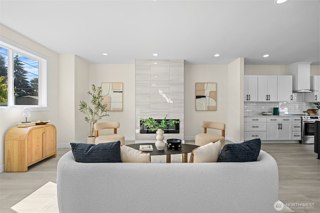 living area featuring light wood finished floors, recessed lighting, and baseboards