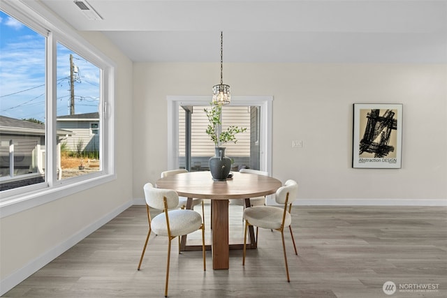 dining room featuring visible vents, plenty of natural light, light wood-type flooring, and baseboards