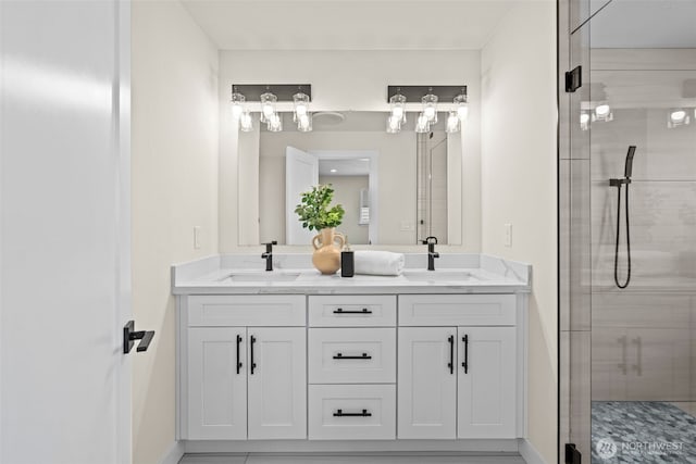 full bathroom with double vanity, a stall shower, and a sink