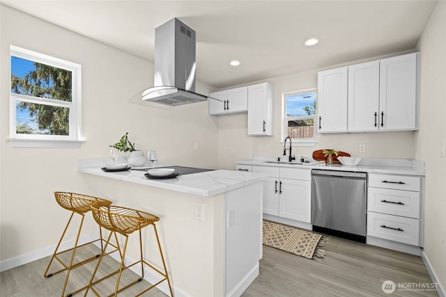 kitchen with range hood, a breakfast bar area, a sink, white cabinets, and dishwasher