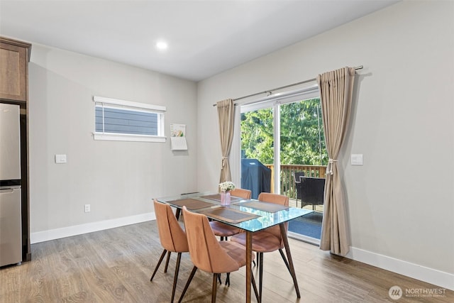 dining space featuring baseboards and light wood finished floors