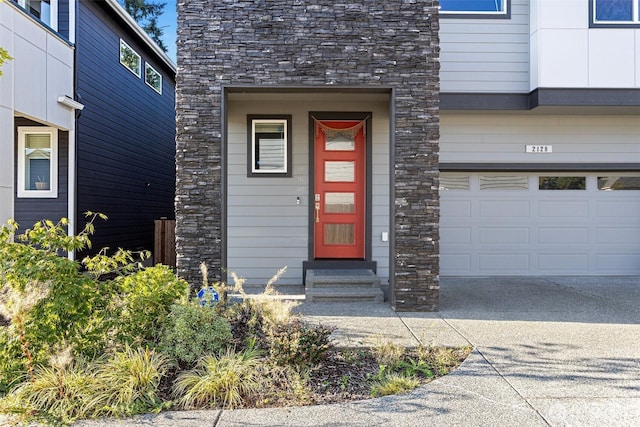 property entrance featuring stone siding and a garage