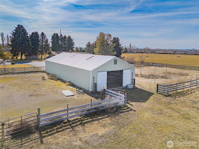 view of pole building with a rural view and fence
