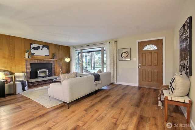 living room featuring baseboards, wood finished floors, and wood walls