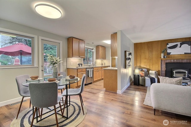 dining room with visible vents, baseboards, light wood-style flooring, and wood walls