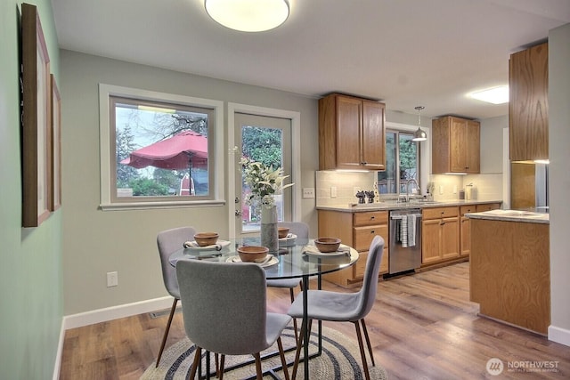 dining space with baseboards and light wood finished floors