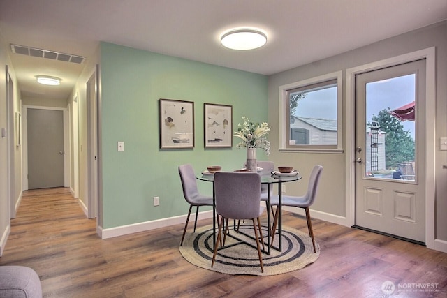 dining space with visible vents, baseboards, and wood finished floors