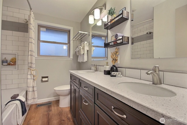 full bath with a sink, visible vents, toilet, and wood finished floors