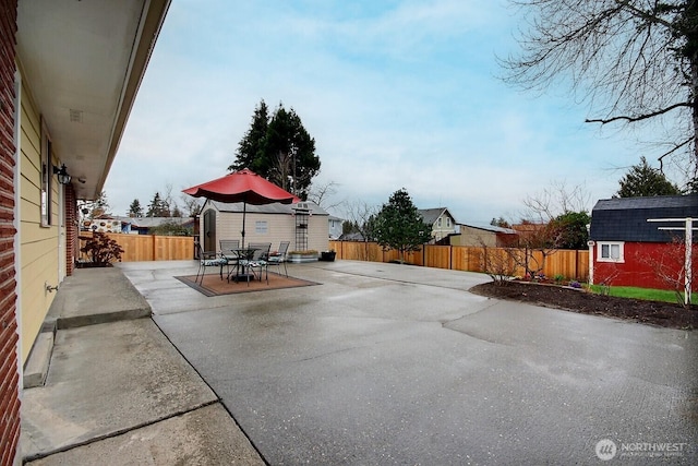 view of patio / terrace featuring a storage shed, an outbuilding, and a fenced backyard