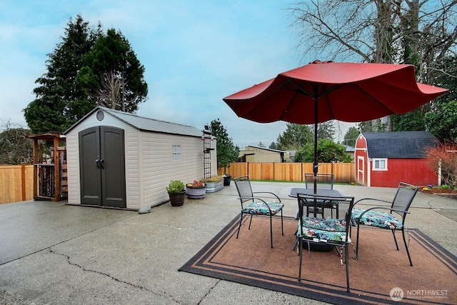 view of patio / terrace with outdoor dining area, a storage shed, an outdoor structure, and fence