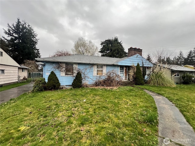 view of front of property featuring a chimney and a front lawn