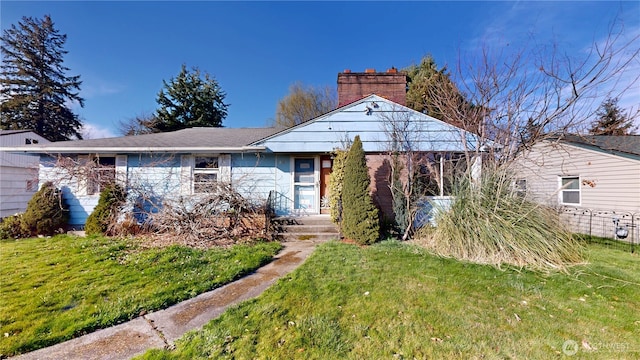 view of front facade featuring a chimney and a front lawn