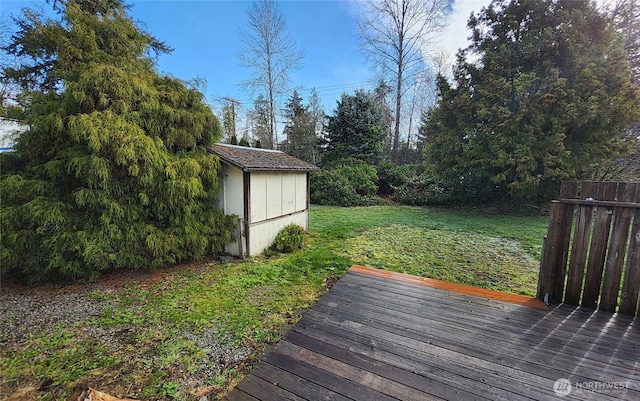 view of yard featuring a wooden deck, an outbuilding, and a shed