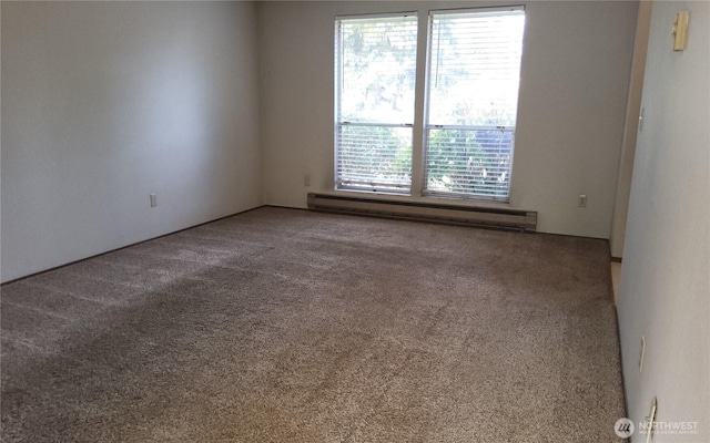 spare room with baseboard heating and carpet