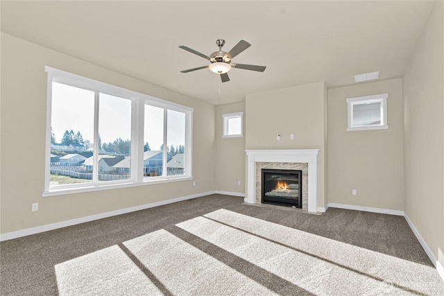 unfurnished living room with visible vents, a ceiling fan, a high end fireplace, carpet flooring, and baseboards