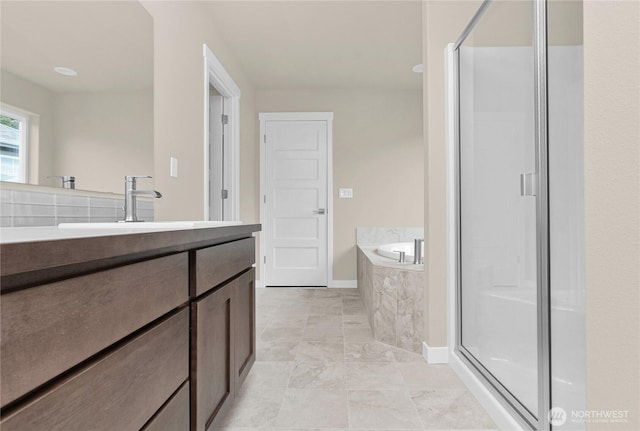 full bathroom with vanity, a garden tub, and a shower stall