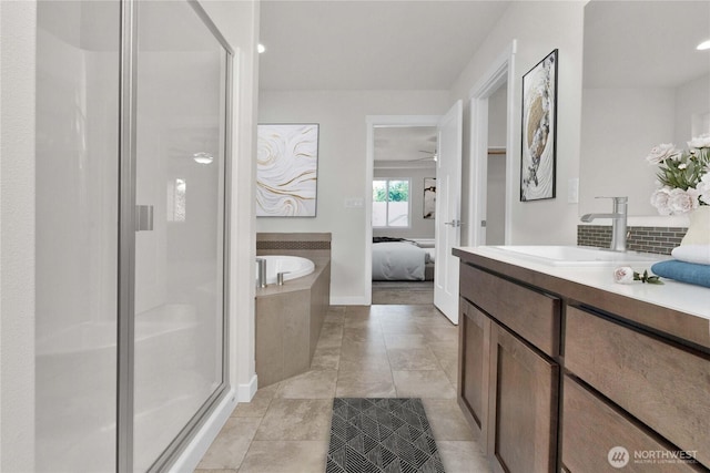 bathroom featuring vanity, a garden tub, a stall shower, and connected bathroom