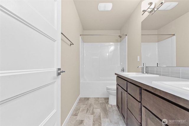 bathroom featuring backsplash, toilet, double vanity, shower / bathing tub combination, and a sink