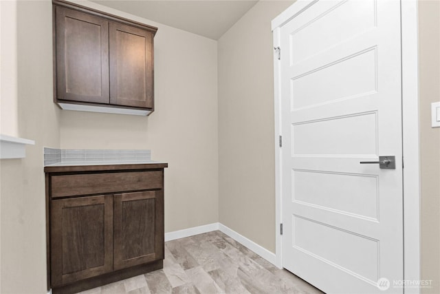 clothes washing area featuring baseboards