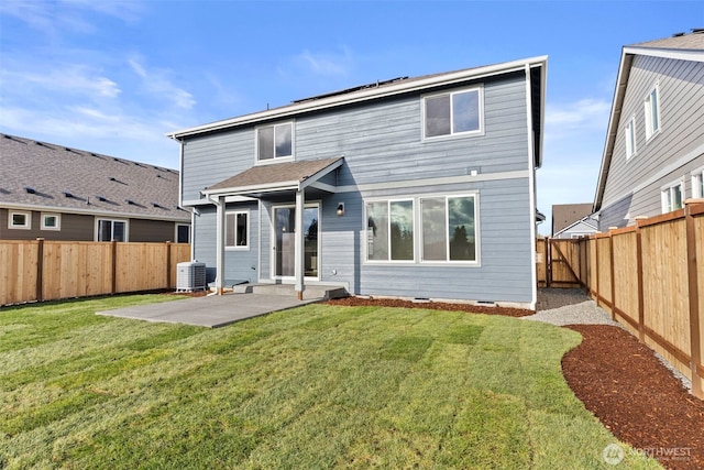 back of property with a patio, a lawn, a fenced backyard, and central AC