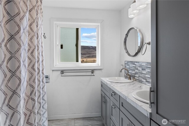 14530 Rutherford Rd, Yakima, WA 98903 - bathroom with marble look tiles, baseboards, backsplash, and double vanity