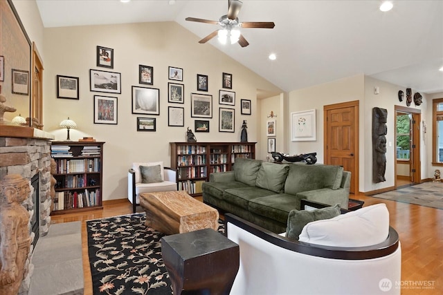 living room featuring vaulted ceiling, a ceiling fan, and wood finished floors