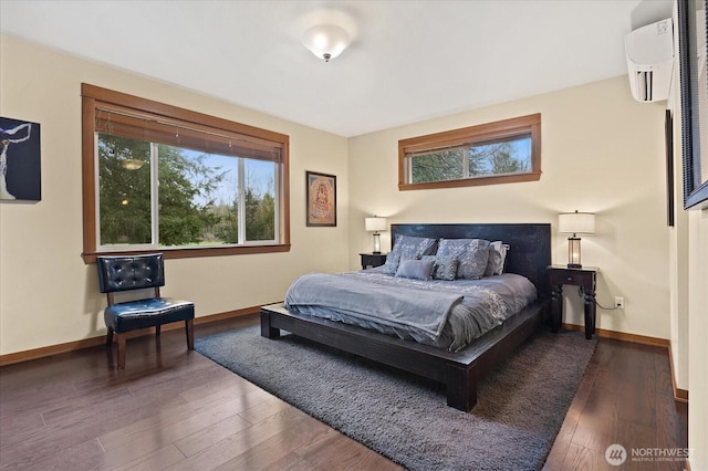 bedroom featuring multiple windows, a wall mounted air conditioner, baseboards, and wood-type flooring