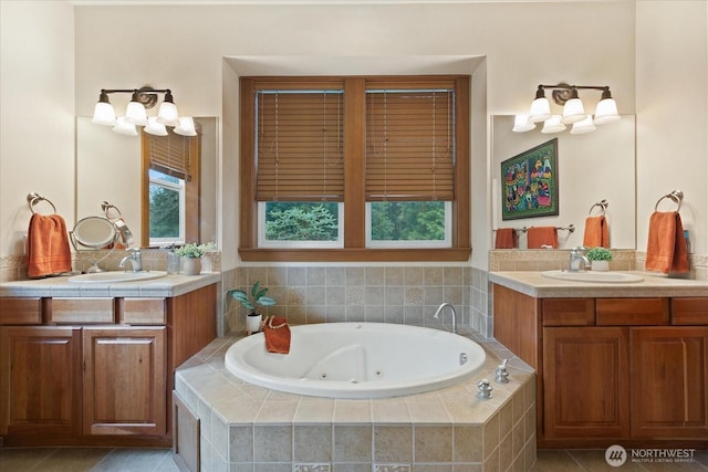 full bath with a jetted tub, two vanities, and a sink