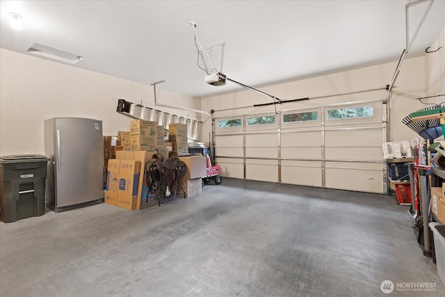 garage with a garage door opener and freestanding refrigerator