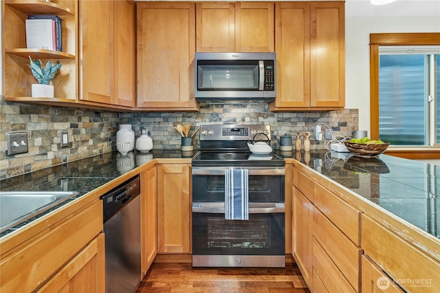 kitchen with dark wood-style floors, a sink, stainless steel appliances, tile counters, and backsplash