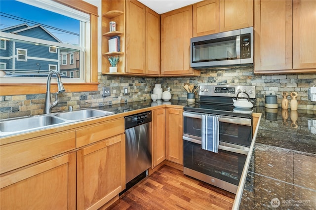 kitchen featuring a sink, decorative backsplash, appliances with stainless steel finishes, wood finished floors, and open shelves