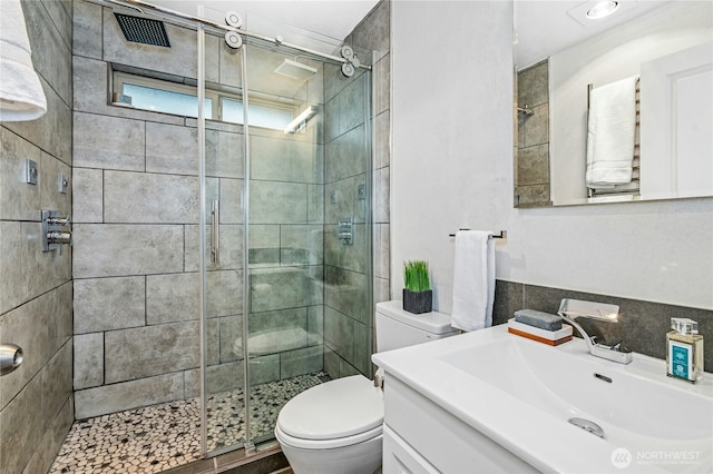 bathroom featuring vanity, toilet, and a stall shower