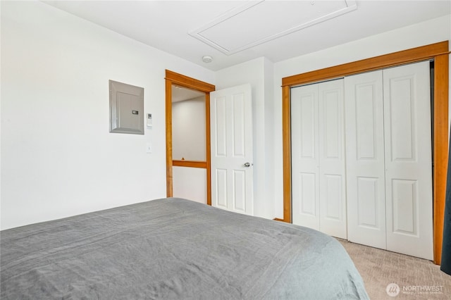 unfurnished bedroom featuring electric panel, a closet, light carpet, and attic access