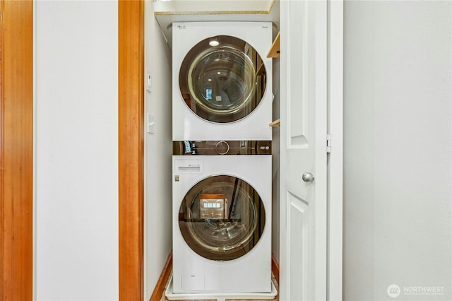 washroom featuring stacked washer and dryer and laundry area