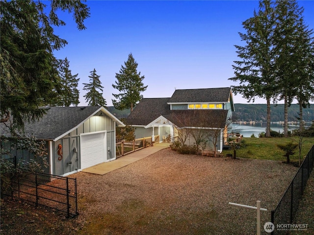 view of front of property with fence, board and batten siding, and driveway