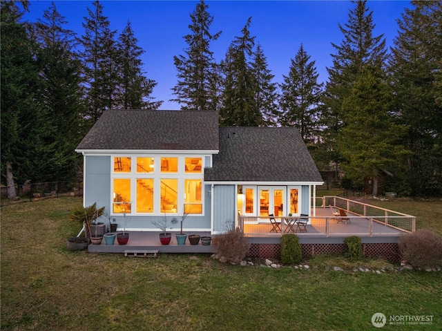 rear view of house with a shingled roof, a yard, fence, and a wooden deck