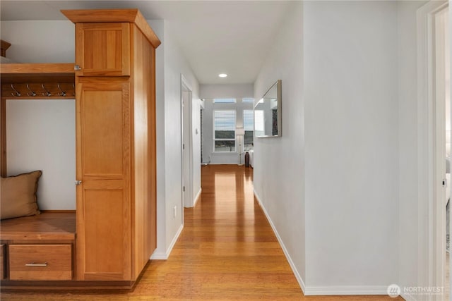 corridor featuring light wood-style floors and baseboards