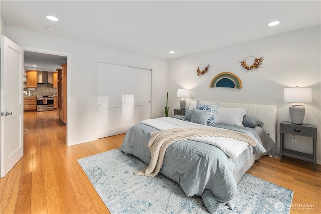 bedroom featuring recessed lighting, a closet, and light wood-style floors