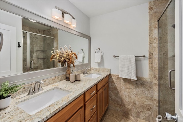 full bath featuring double vanity, a shower stall, tile walls, and a sink