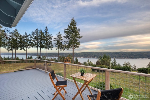 wooden deck featuring a water view and a lawn