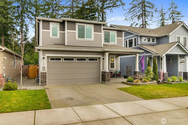 view of front facade with a garage, stone siding, driveway, and fence