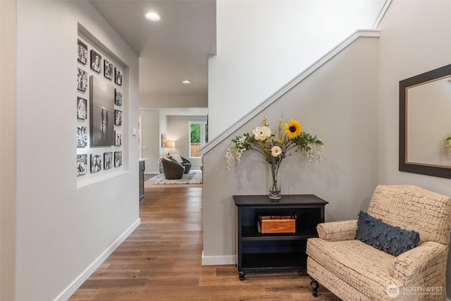 hallway featuring stairs, wood finished floors, and baseboards