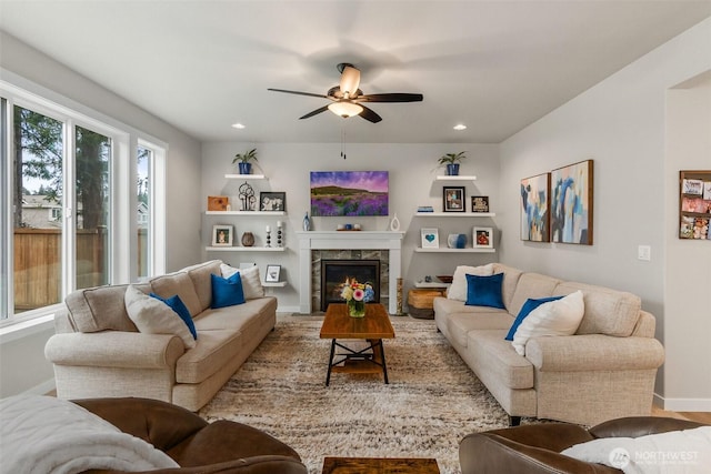 living room featuring recessed lighting, a premium fireplace, baseboards, and a ceiling fan