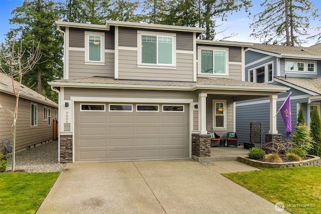 view of front of home with stone siding, an attached garage, and driveway