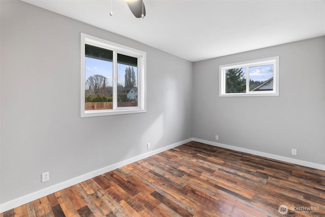 unfurnished room with dark wood-style floors, ceiling fan, and baseboards