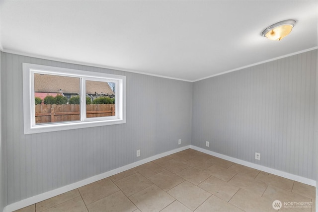 tiled empty room with baseboards and ornamental molding