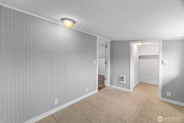 interior space featuring a closet, heating unit, light tile patterned flooring, and a spacious closet